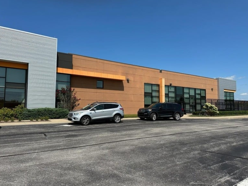 a photo of a building with two vehicles in front of it