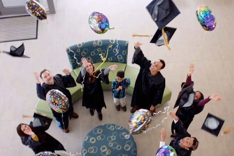 group photo of graduates tossing their caps into the air