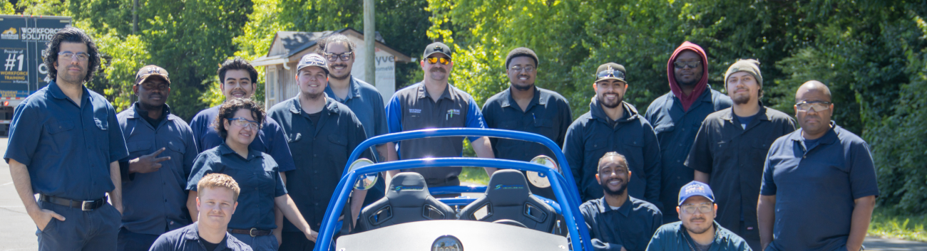 group of automotive students with an electric car they built