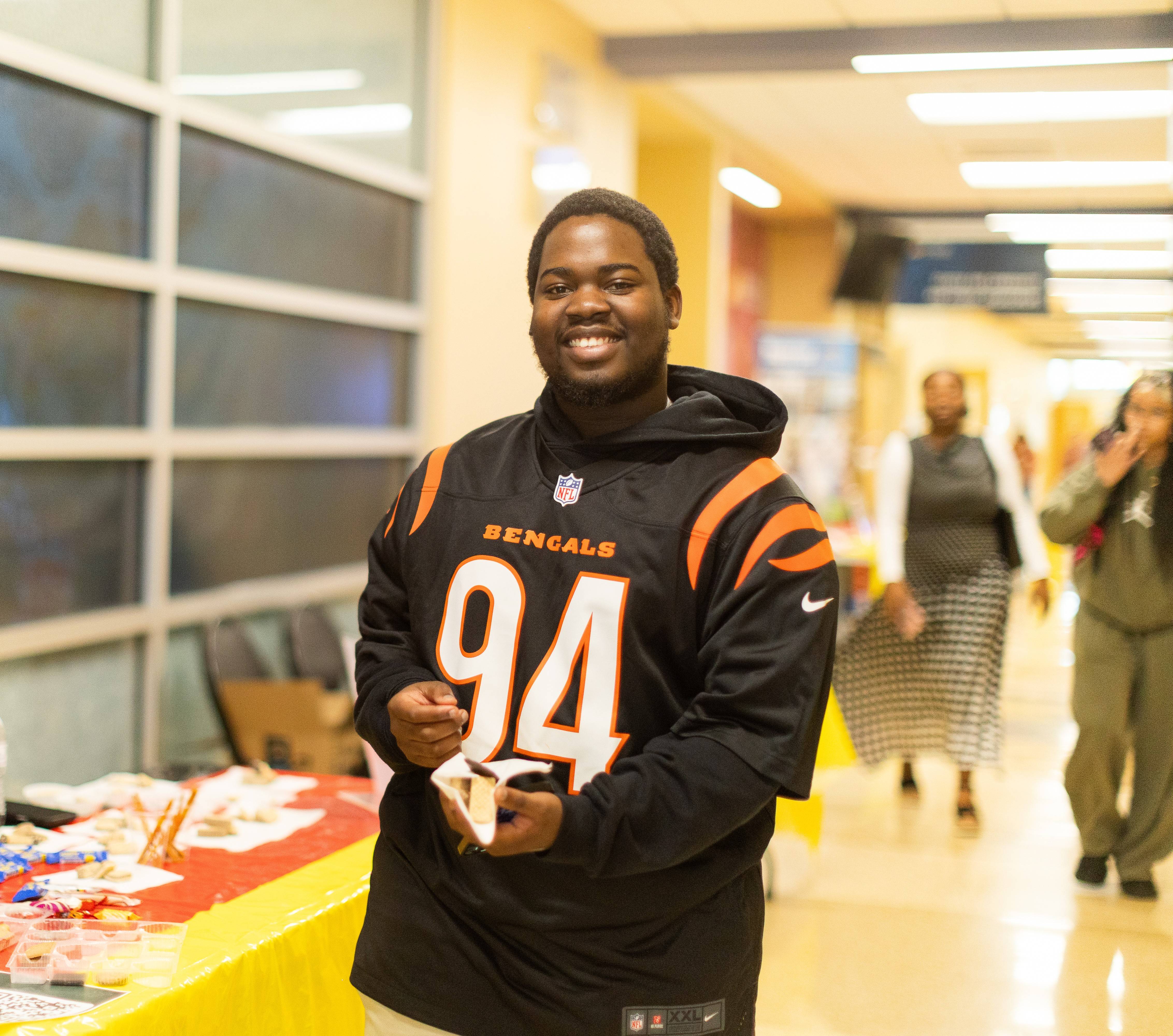 a student stands in the hallway smiling