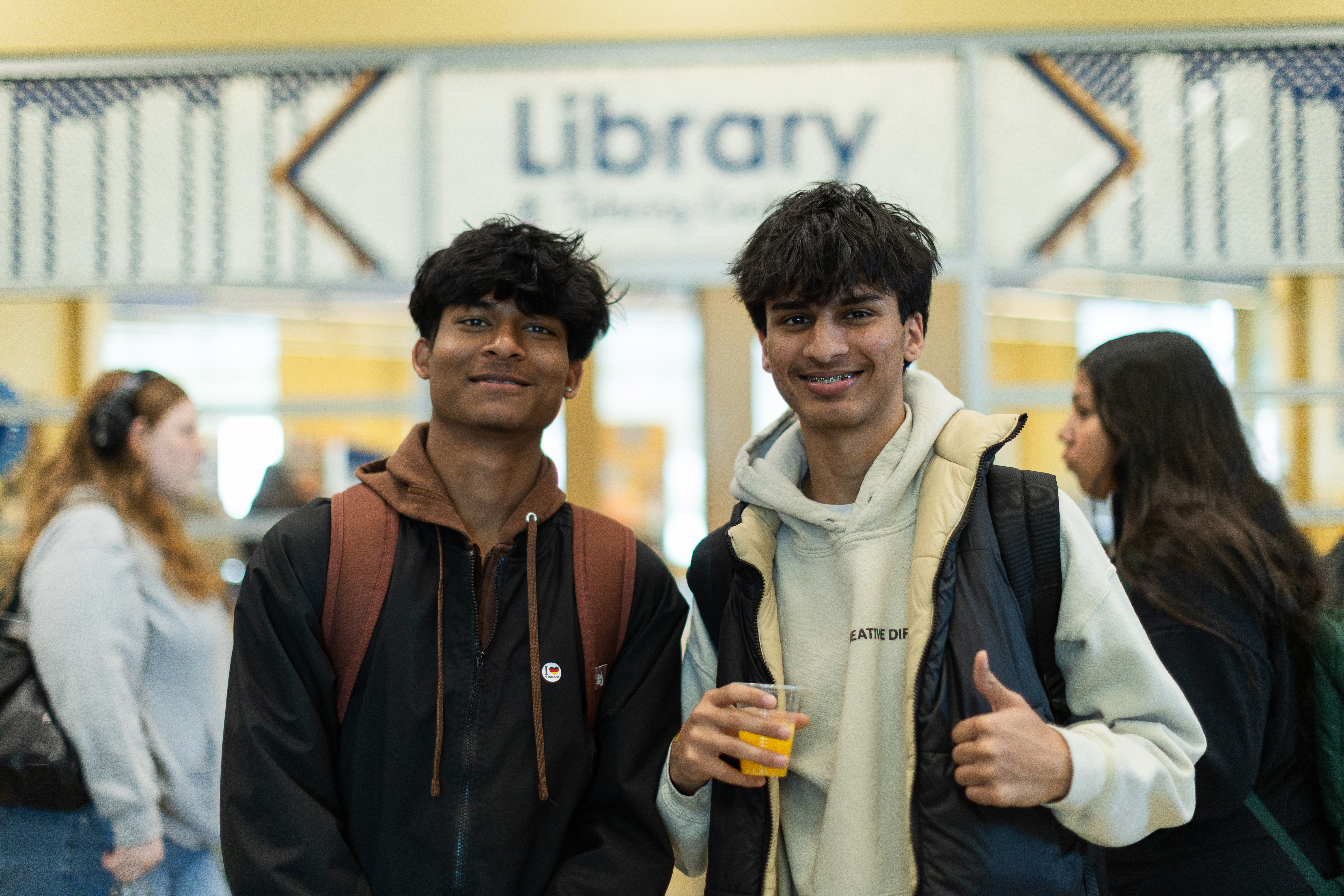 two students stand together in front of the library