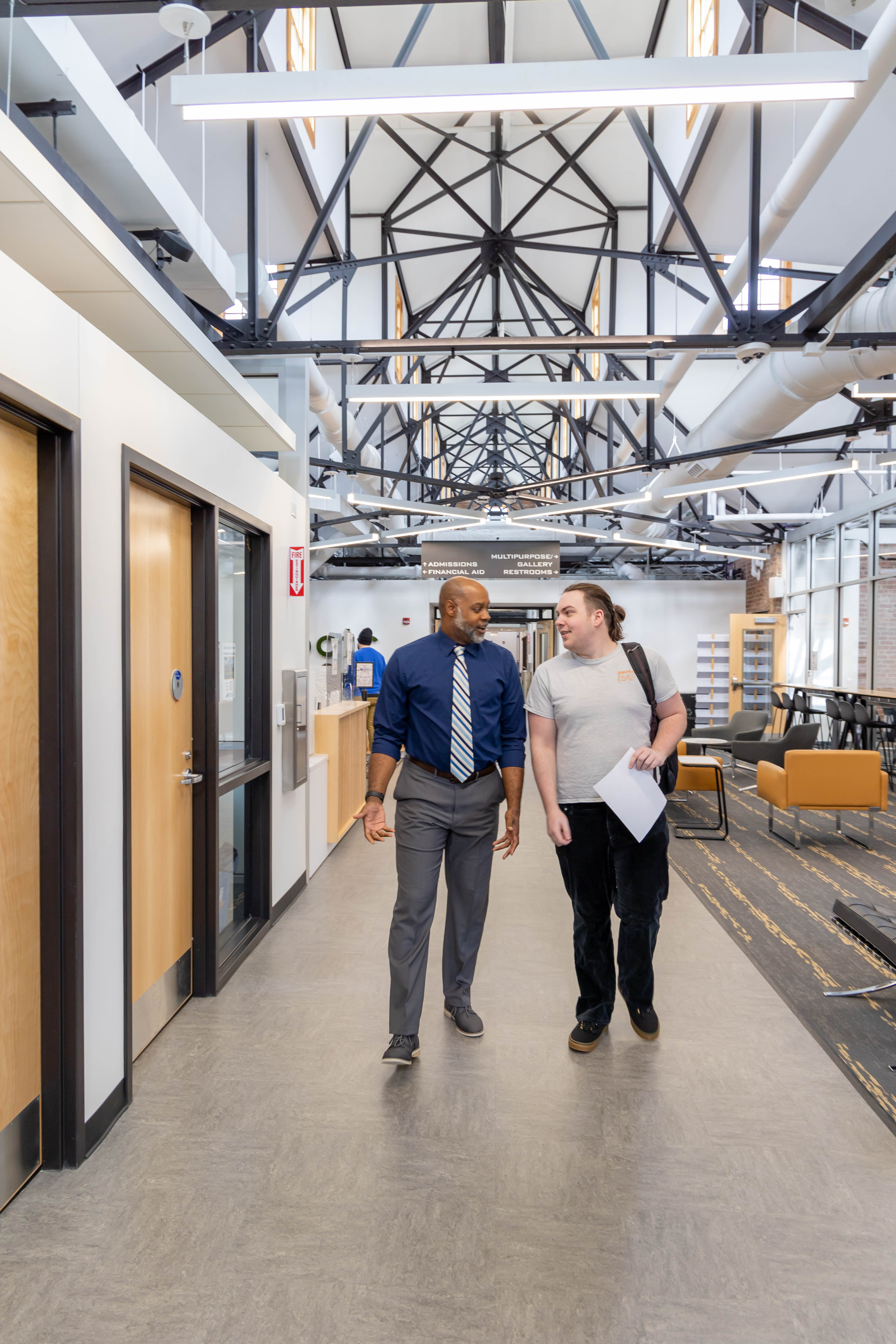 an advisor walks with a student in the den