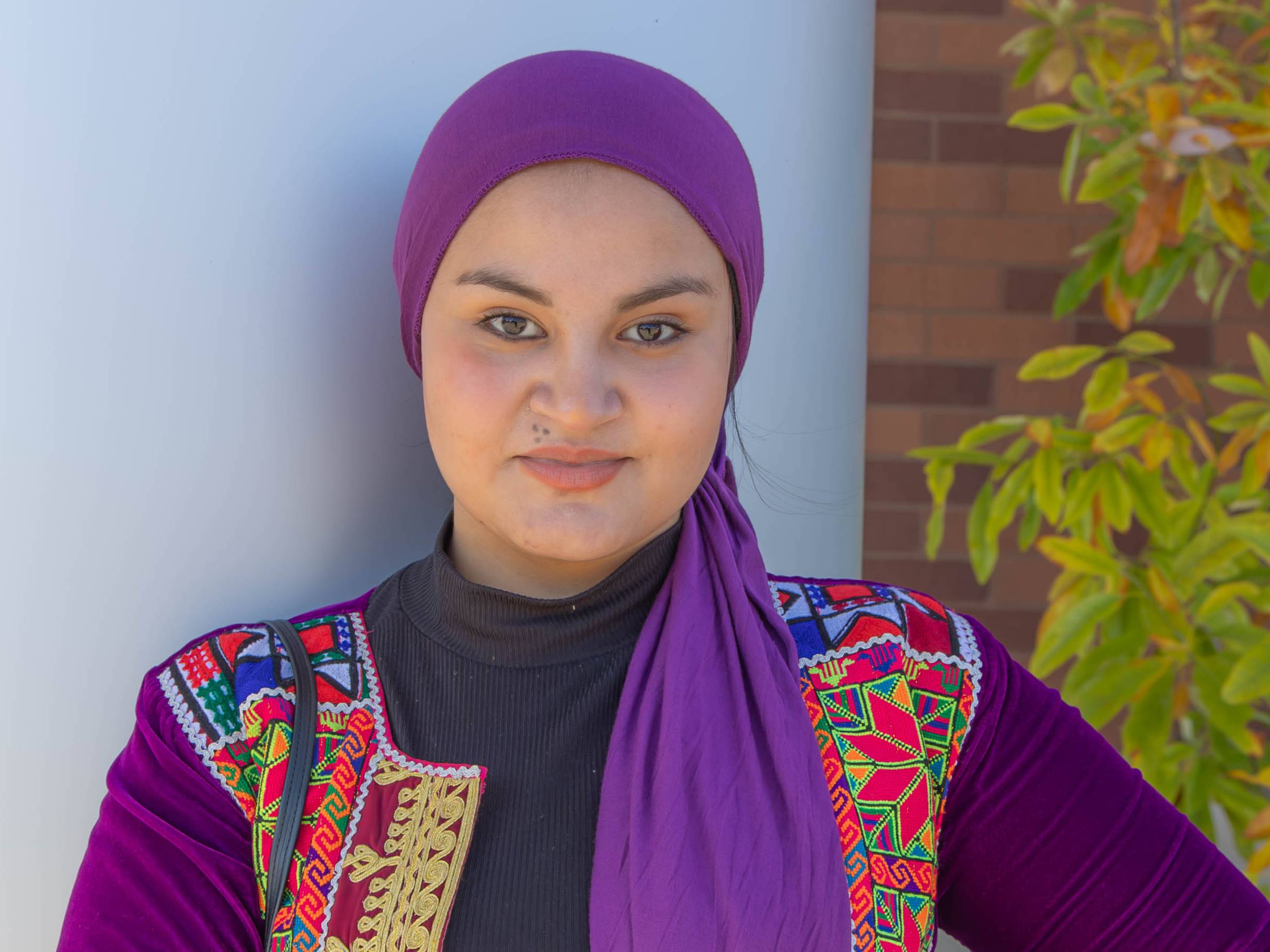 a refugee student poses outside the classroom building
