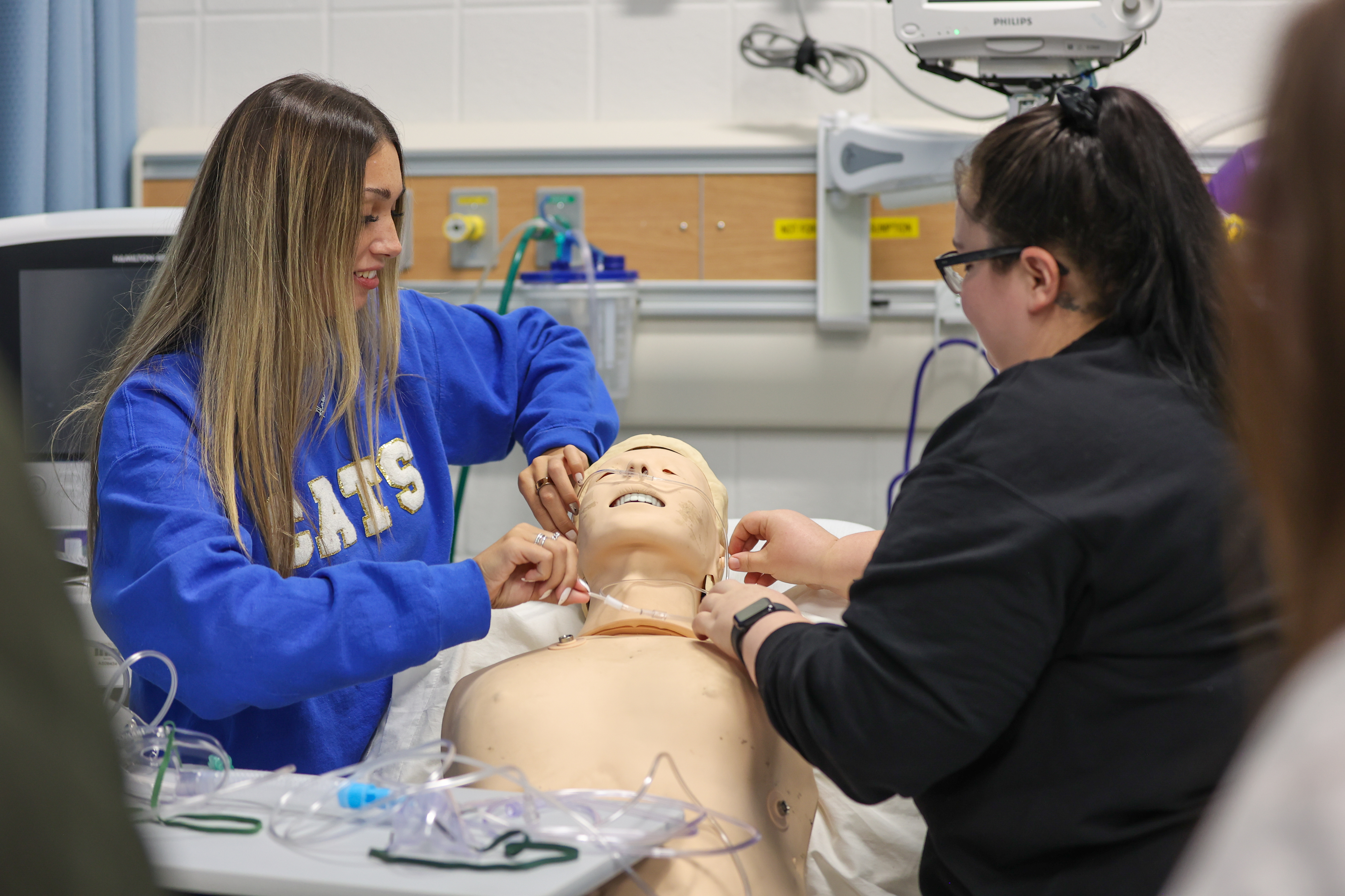two respiratory care students work on a mannequin