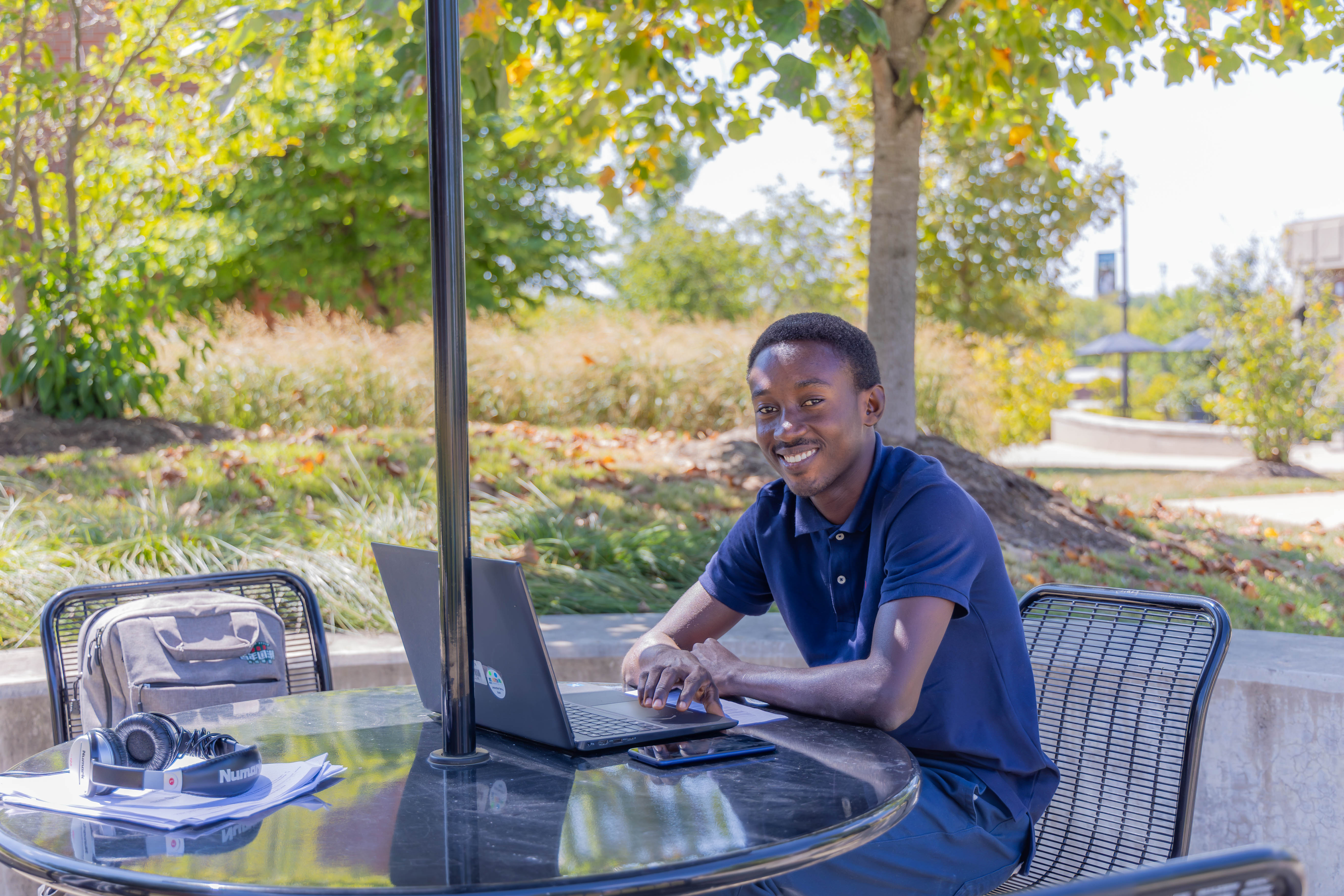 a student sitting outside with his laptop
