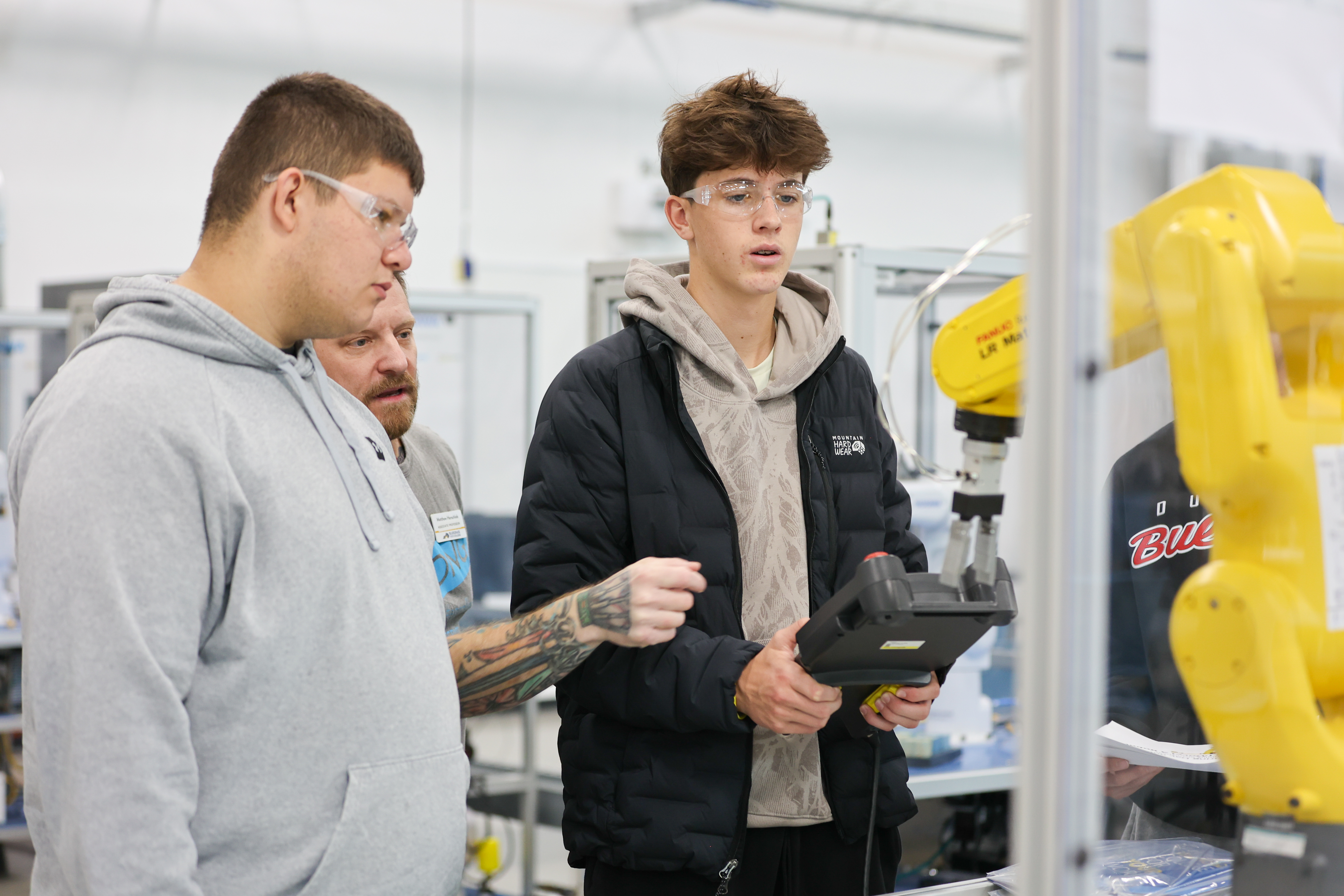 students work with robotic arm in advanced manufacturing center