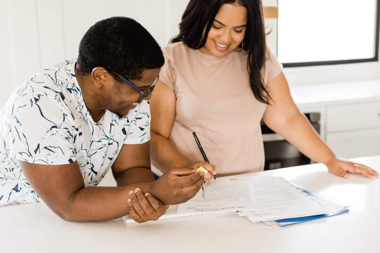 two parents smile while completing paperwork