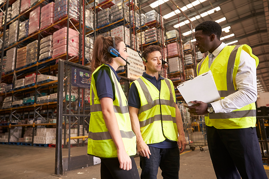 people in safety vests in warehouse