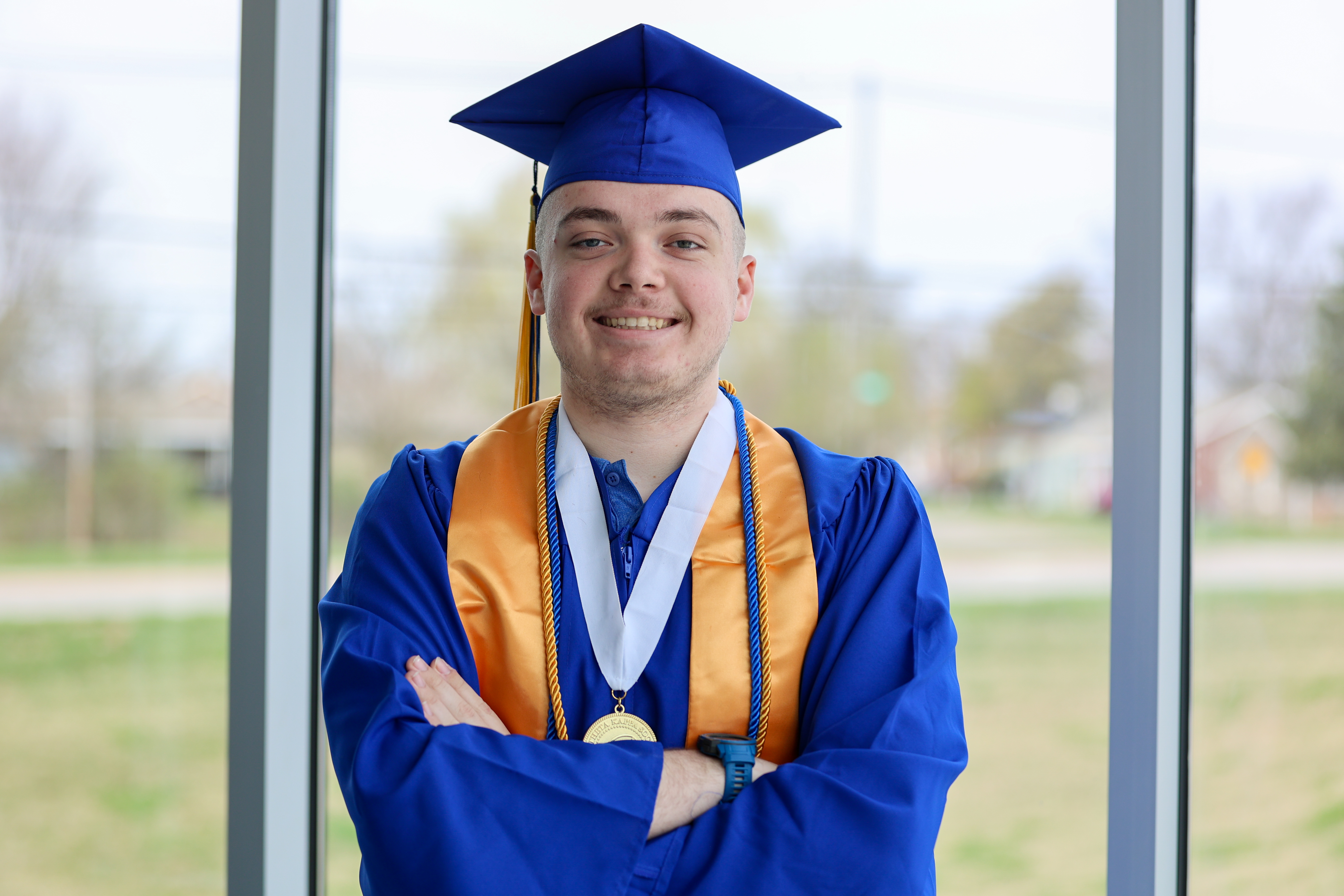 Person with arms crossed over chest while smiling