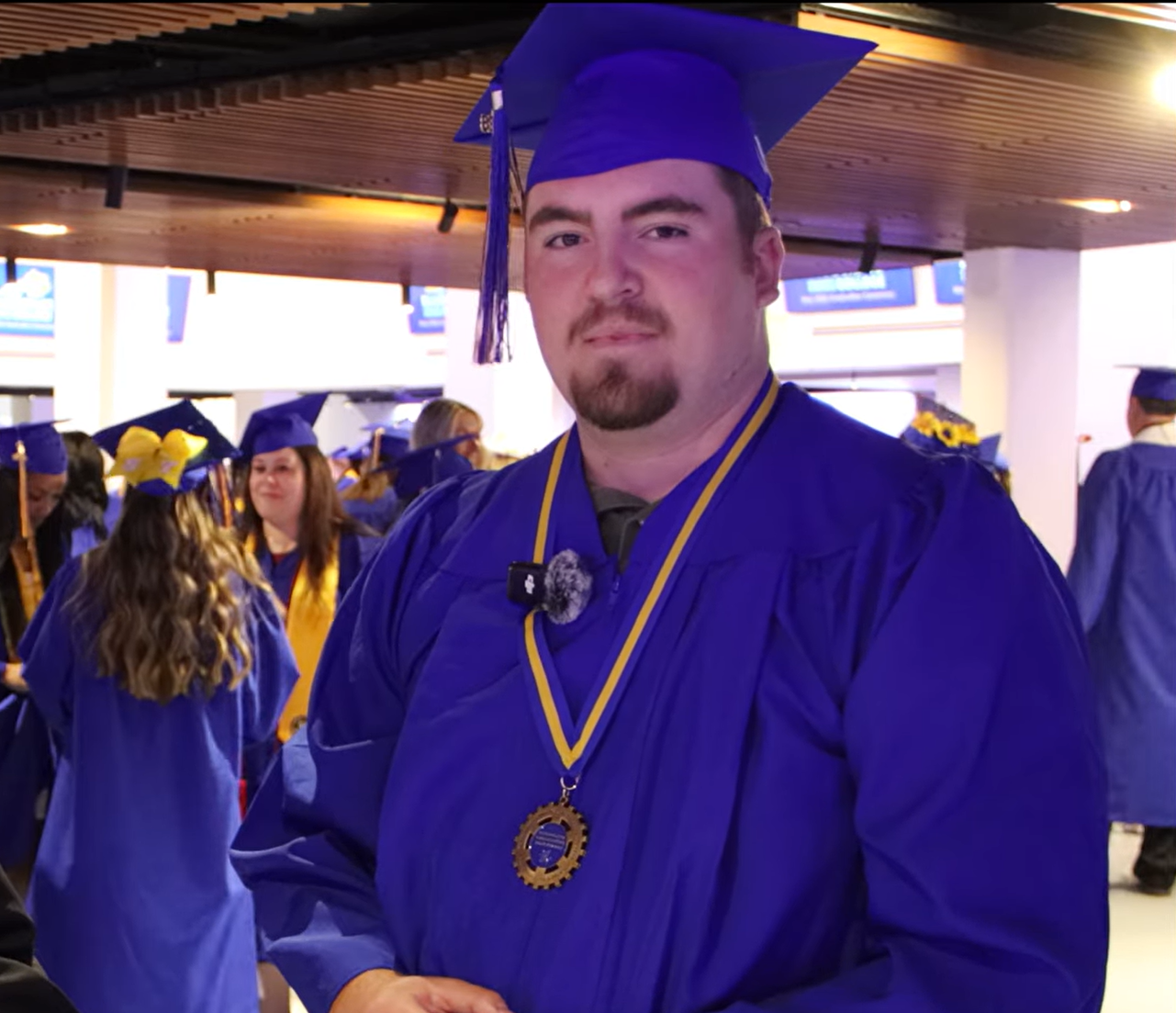 Person standing wearing graduation garb