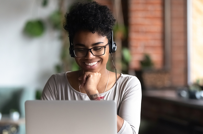 Woman Watching Video on Laptop with Headphones