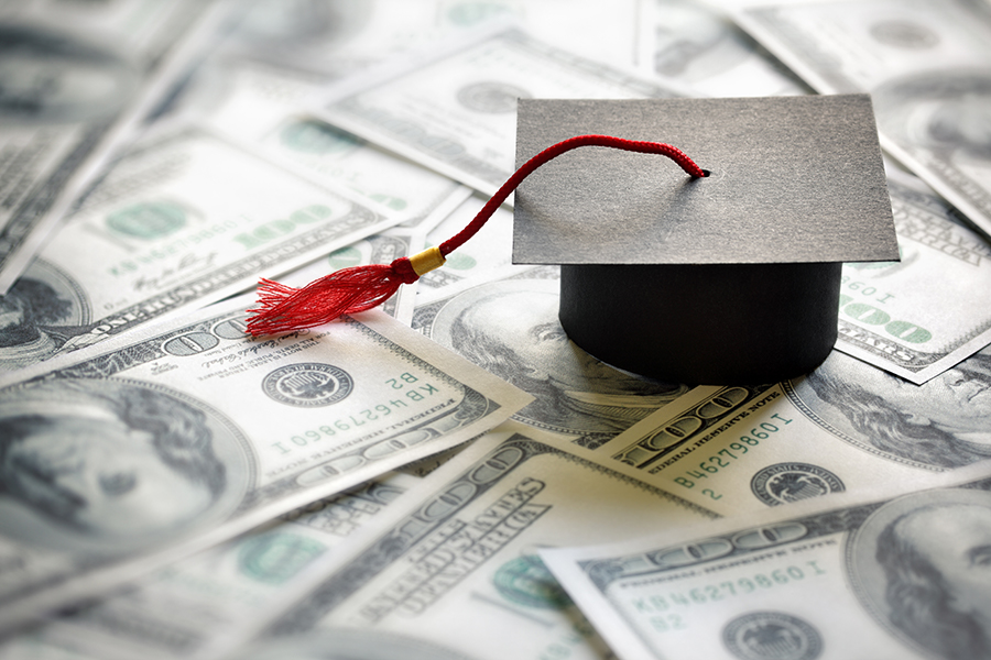 graduation cap on spread of money