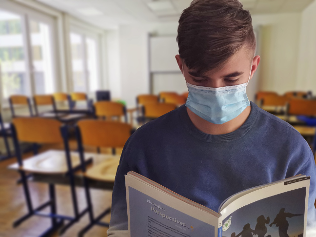 student reading while wearing mask