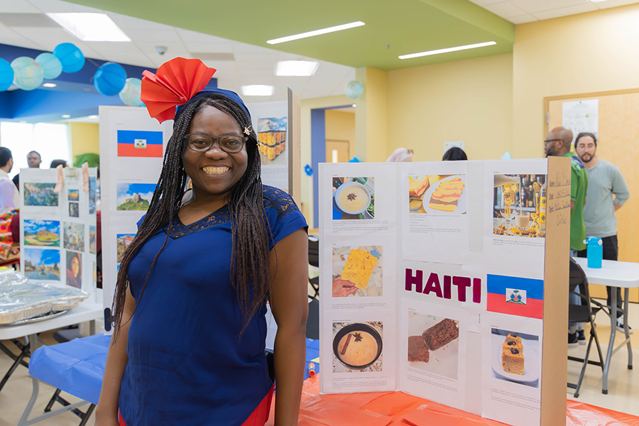 student in front of tri-fold display for Haiti