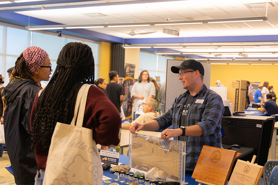 two people at a program information table from 2024 open house