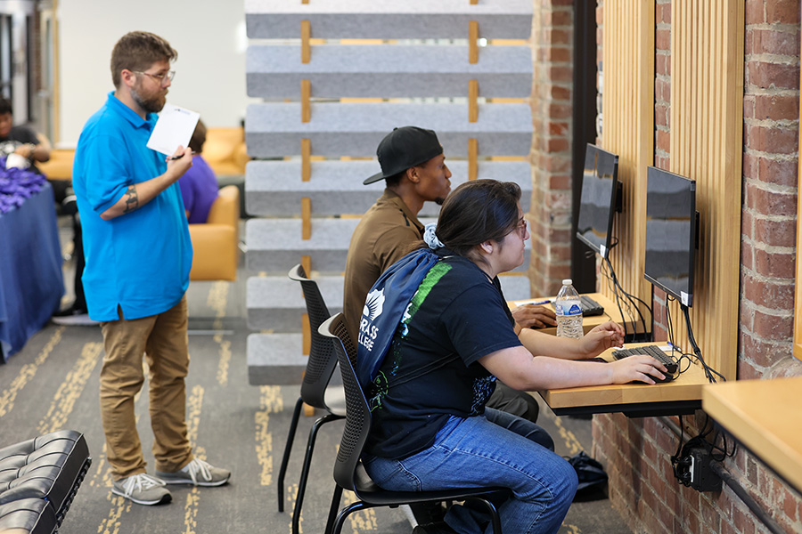 people using computers with admission staff ready to help